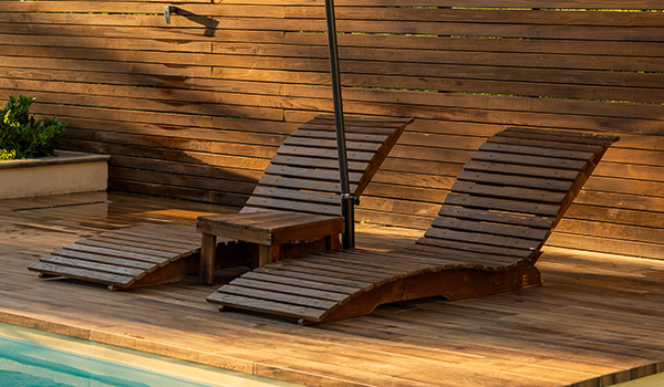 Transats bois piscine lumière dorée — Privilège